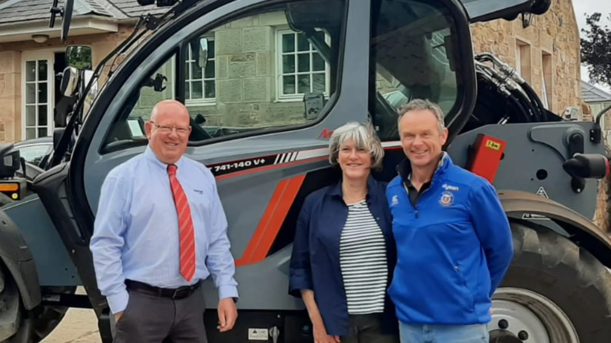 Three people standing beside a Manitou MLT 741-140 V+ telehandler.